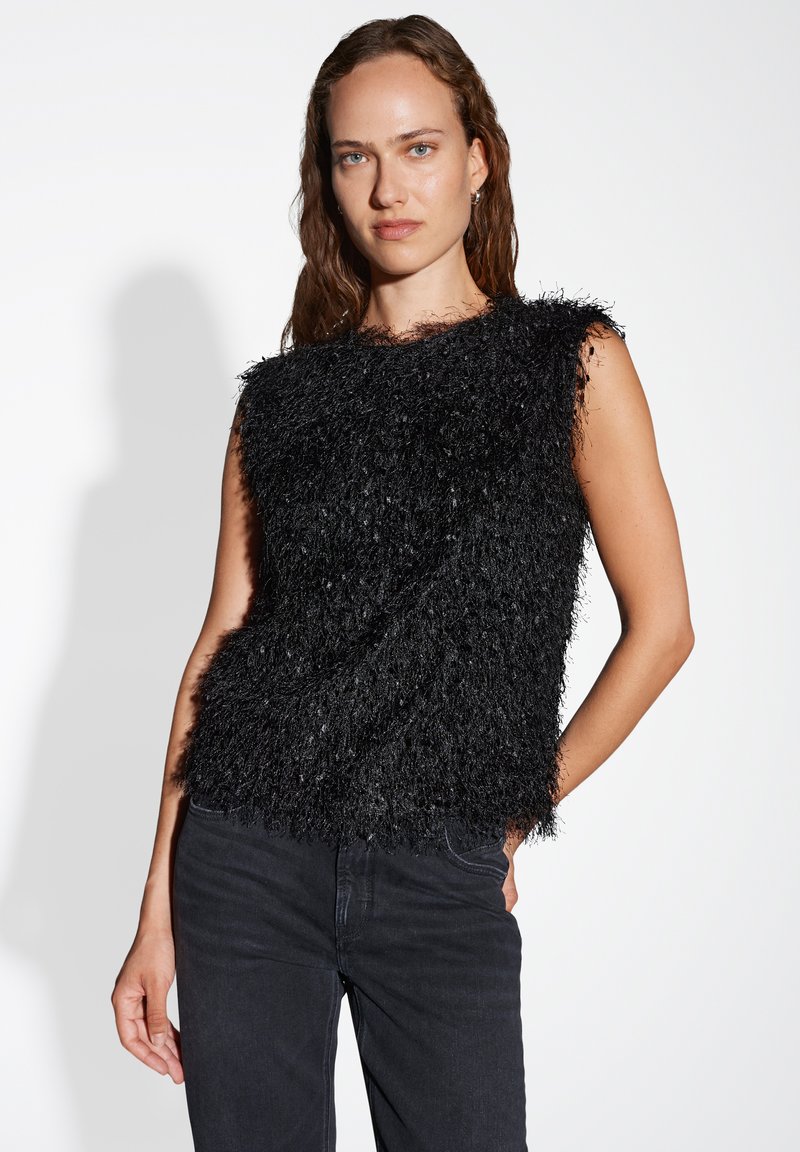 Zwarte mouwloze top met een gestructureerd, fluffy ontwerp; gemaakt van een zachte stof, heeft een losse pasvorm en een ronde halslijn. Gecombineerd met donkere jeans.