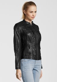 Schwarze Lederjacke mit Reißverschluss, Stehkragen und mehreren Reißverschlusstaschen. Verfügt über gestickte Details an den Schultern und Ärmeln.