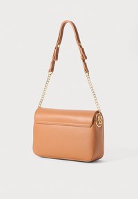 Sac à main en cuir tan de forme rectangulaire, avec un rabat supérieur, une chaîne et une sangle en cuir, et un accent logo circulaire en or. Texture lisse.
