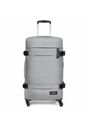 Gray wheeled suitcase made of textured fabric. Features a retractable handle, adjustable straps, and a front pocket with zipper.