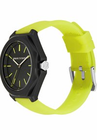 Reloj octagonal negro con un rostro texturizado, correa de silicona verde fluorescente, herrajes plateados y marcadores de horas amarillos en contraste.