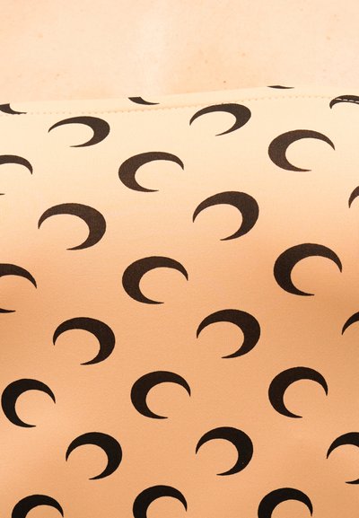 Bež tkanina s ponavljajočim se črnim vzorcem polmeseca v diagonalnih vrstah.