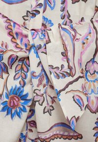 Tessuto a motivo floreale con design blu, rosa e marrone su uno sfondo chiaro, con un dettaglio annodato in vita.