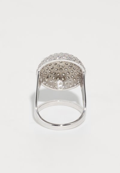 Silver ring featuring a textured, rounded top with crystal embellishments and a smooth band, showcasing a modern design.