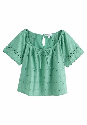 Blouse verte menthe en tissu texturé, avec des manches courtes, un dos en trou de serrure, un devant à nouer et des broderies.