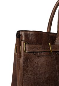 Ciemnobrązowa skórzana torebka o teksturowanej powierzchni, z detalem w postaci mosiężnej klamry i dwiema solidnymi rączkami na białym tle.