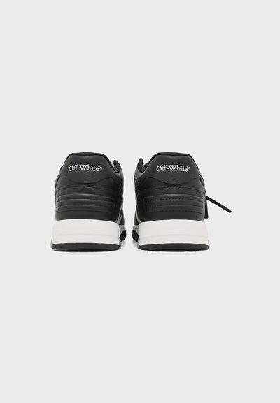 Ζευγάρι ασπρόμαυρα αθλητικά παπούτσια Off-White, εμφανιζόμενα από πίσω, με μαύρο επάνω μέρος, λευκές ενδιάμεσες σόλες και λευκό λογότυπο "Off-White" στις φτέρνες.