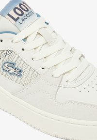 Baskets en cuir blanc avec des accents en daim, des détails en maille et une marque bleue sur la languette. Elles présentent des lacets plats blancs et des perforations sur le bout.