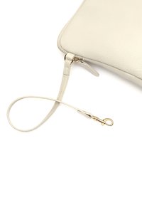 Lichtbeige leren clutch met een gestructureerd oppervlak, ritssluiting en een afneembare schouderband met een gouden sluiting.