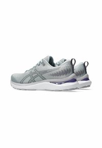 Light grey athletic shoes with a textured knit upper, supportive midsole, and purple accents. Features a padded collar and laces.