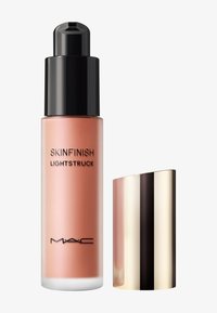 Pumpeflaske af MAC Skinfinish Lightstruck flydende highlighter med sort pumpe og skinnende guldhætte på hvid baggrund.