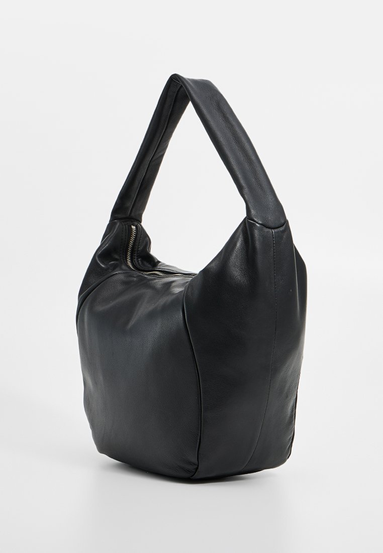 Schwarze Leder-Schultertasche mit runder Form, breitem Griff und Reißverschluss. Glatte Textur mit minimalen Nähdetails.