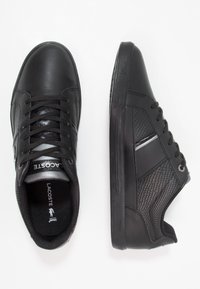 Svarta sneakers av slät och strukturerad läder, med kontrasterande paneler, runda snören och en gummisula med subtil branding.