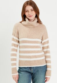 Suéter a rayas beige y blanco con cuello de tortuga acanalado y puños. Textura suave, forma ajustada y un ajuste relajado en el cuerpo.