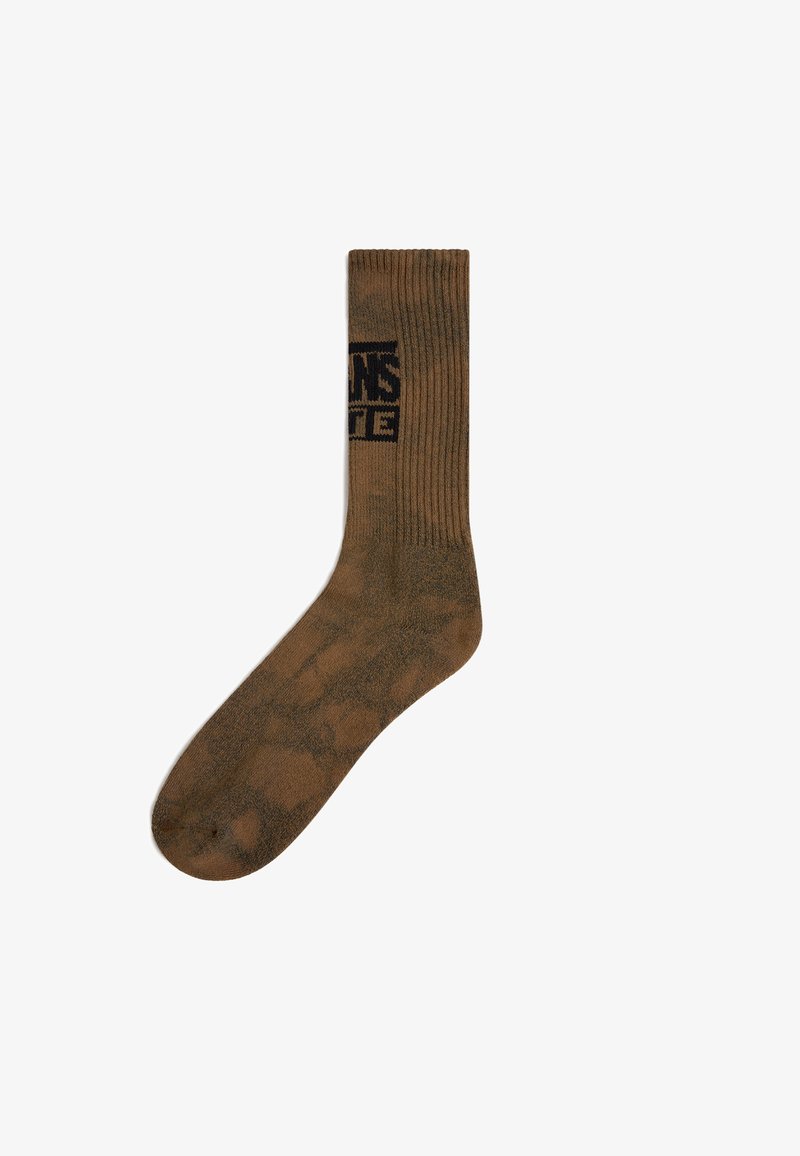 Brun crew-sok med ribbet design og camouflagemønster. Har et kontrastfyldt sort logo på den øverste del.