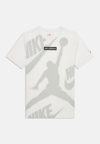 Hvit bomulls t-skjorte med en stor grå silhuett av en hoppende figur og overlappende "NIKE"-logoer i lys grå. Svart "AIR JORDAN"-merke.