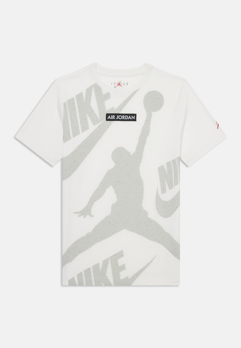 Hvit bomulls t-skjorte med en stor grå silhuett av en hoppende figur og overlappende "NIKE"-logoer i lys grå. Svart "AIR JORDAN"-merke.