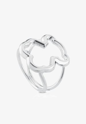 Anello in argento traforato con design astratto a forma floreale e doppia banda sottile su sfondo bianco.