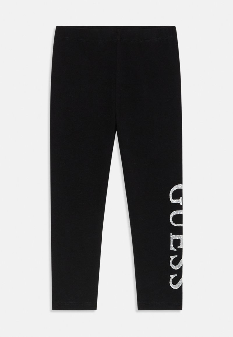 Leggings negre dintr-un material moale, având un logo „GUESS” argintiu, strălucitor, imprimat vertical pe partea stângă. Formă subțire, ajustată.