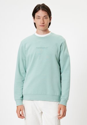 Sudadera verde menta claro con mangas largas, cuello redondo y texto bordado "CONFIDENT" en el pecho. Material suave y liso.