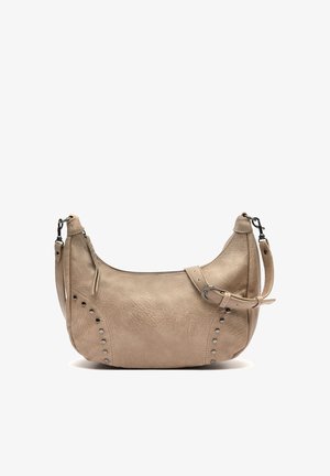 Béžová kožená kabelka na rameno so striebornými cvočkami, zipsovým zapínaním a nastaviteľným remienkom so sponou, zobrazená na bielom pozadí.