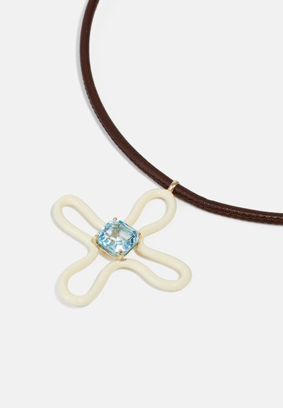Collana in pelle marrone con pendente in polimero color crema a forma di croce, caratterizzato da una gemma quadrata azzurro chiaro al centro.