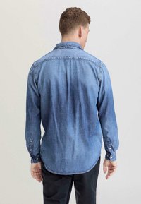 Lichtblauwe denim overhemd met een button-down kraag, lange mouwen en een gebogen zoom. Heeft een textuur stof met een vervaagde uitstraling.