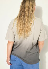 Lehký, krátký rukáv tričko s ombre vzorem, přecházejícím od světle béžové po tmavě šedou, vyrobené z měkké látky.