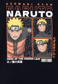Camiseta negra con un gráfico del personaje de dibujos animados Naruto, con cabello amarillo y puntiagudo, ropa naranja y negra, y texto que detalla el Clan Uzumaki.
