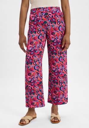 Helle, gemusterte Weite-Hosen mit Wirbeln aus Pink, Lila und Grün auf einem lebhaften Hintergrund, aus leichtem Stoff gefertigt.