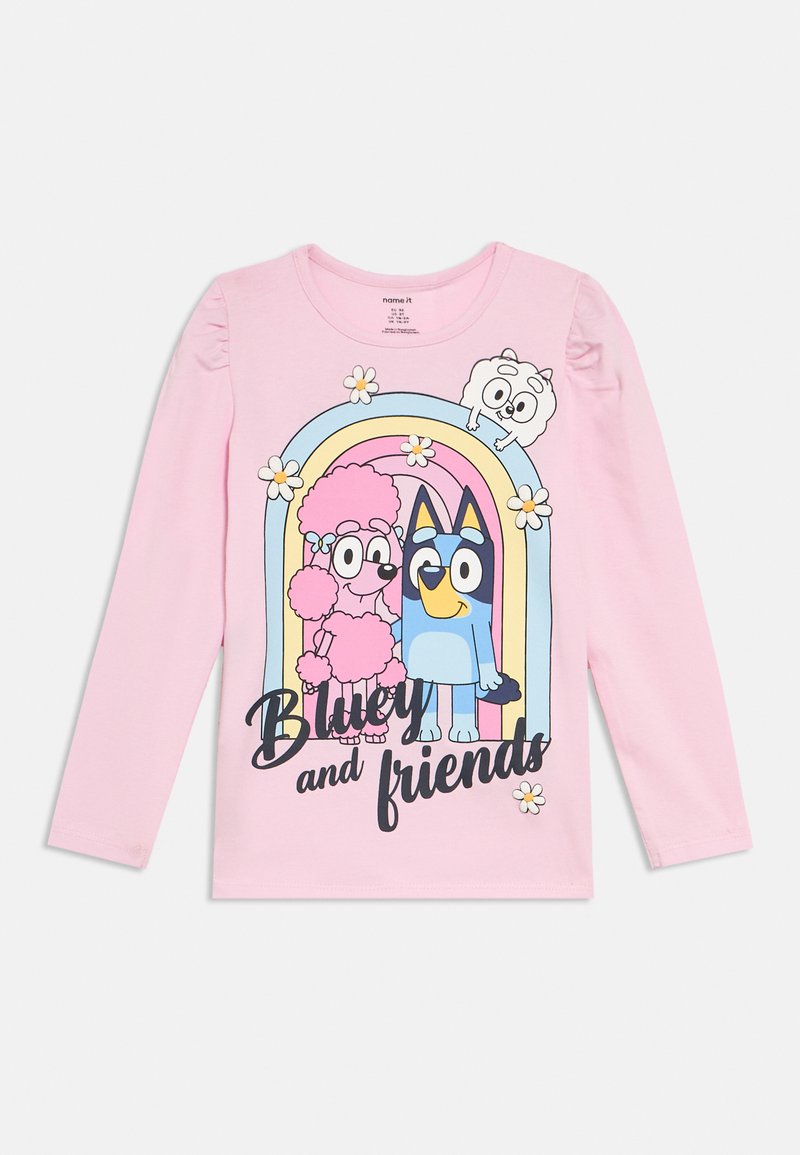 Różowa koszulka z długim rękawem z grafiką postaci z kreskówek na tle tęczy i kwiatów. Napis głosi „Bluey i przyjaciele.”