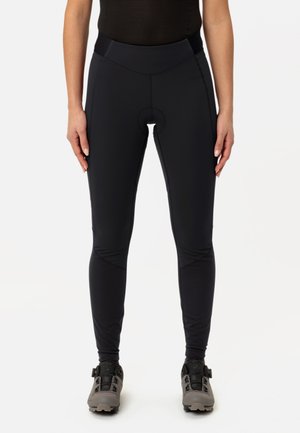 Svart sykkelleggings med høy midje, som har en rund polstring utskjæring, glatt tekstur og tettsittende design med sømdetaljer.