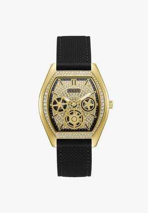 Goudkleurig hexagonaal horloge met een zwarte gestructureerde band. Voorzien van een bezel bezet met kristallen, een ingewikkeld tandwielontwerp op de wijzerplaat en witte wijzers.