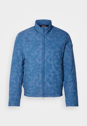 Blue camouflage jacket with a high collar, full zip closure, and textured fabric. Features a smooth finish and elastic cuffs.