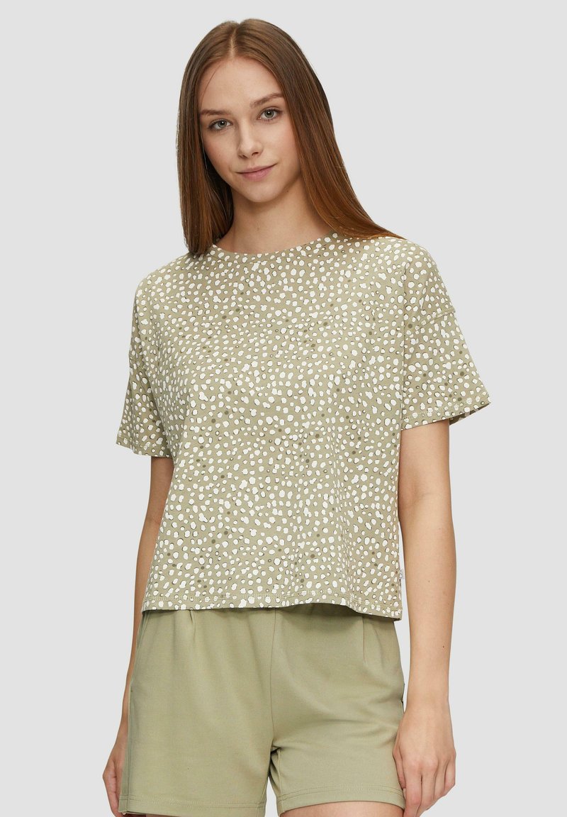 Zielona góra z krótkim rękawem w wzory z białymi kropkami, okrągły dekolt, luźny krój, wykonana z miękkiego materiału, w zestawie z pasującymi zielonymi szortami.