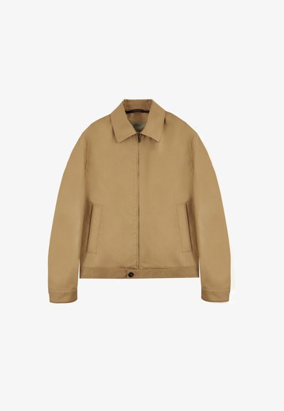 Tan jas met een ritssluiting aan de voorkant, puntkraag, zijzakken en een aansluitende zoom. Gladde textuur en minimalistisch ontwerp.