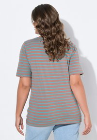 Camiseta de manga corta marrón con rayas horizontales azul claro; textura suave y corte relajado, mostrada desde la parte de atrás sobre un fondo blanco.