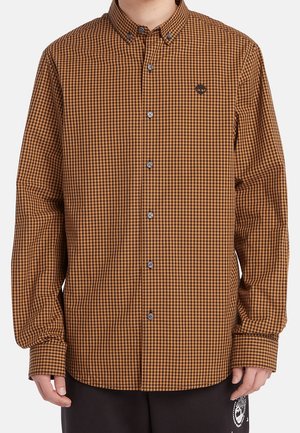 Chemise à carreaux marron et noir à manches longues avec boutons, col boutonné et petit logo brodé sur la poitrine gauche.