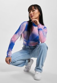 Pika pikkade varrukatega sobiv tops, millel on gradientsedisain roosa ja sinise tooni, väikese rhinestone detailiga; kombinatsiooniks heledam denimist teksad.