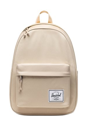 Béžový Herschel batoh s predným vreckom na zips, dvojitým zapínaním na zips, hornou rukoväťou a značkovou nálepkou na spodnom pravom vrecku.