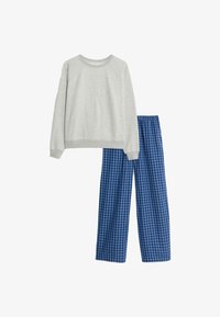 Sudadera de manga larga gris claro combinada con pantalones de pijama a cuadros azules y azul oscuro, exhibida plana sobre un fondo blanco.