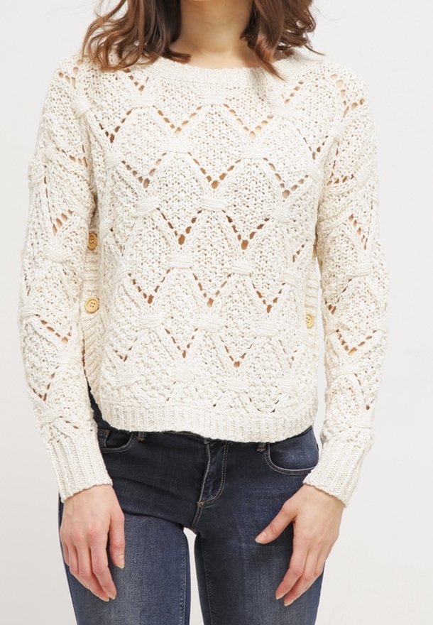 Krämfärgad stickad tröja med ett zigzagmönster, med knappdetaljer på sidan och ribbade manschetter och nederkant. Lätt, strukturerad tyg.