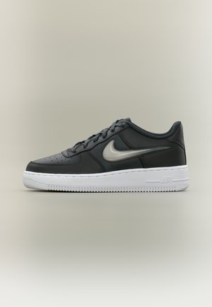 Čierna teniska Nike Air Force 1 s bielou podrážkou a sivým logom swoosh, zobrazená z boku na jednoduchom neutrálnom pozadí.