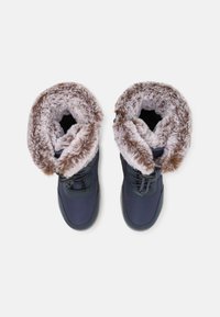 Bottes bleu foncé avec un revers en fausse fourrure et une doublure noire. Elles sont dotées de lacets et d'une semelle en caoutchouc. Extérieur lisse avec un col doux et texturé.