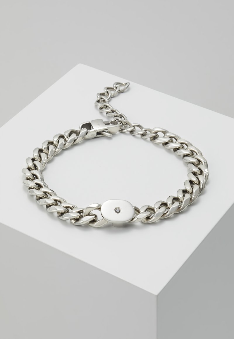 Silberne Metallkette Armband mit ovalem Verschluss und einem kleinen zentralen Stein. Verfügt über ineinandergreifende Glieder mit einer glatten, polierten Oberfläche.