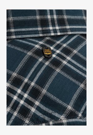 Dunkelblaues Flanellhemd mit weißem und grauem Karomuster. Mit einem schwarzen Etikett mit gelber Schrift "PME LEGEND". Weicher Stoff, gefaltetes Design.