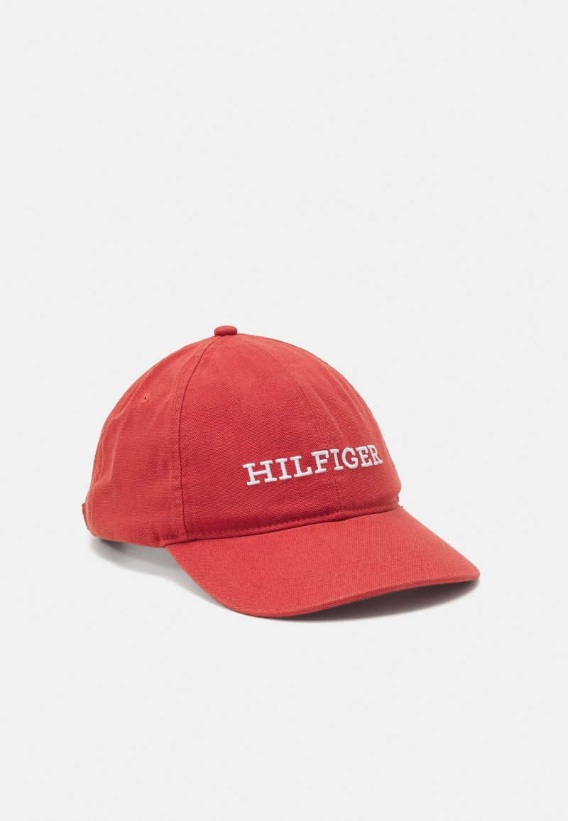 Casquette de baseball rouge avec une visière incurvée et le texte brodé en blanc "HILFIGER" sur le devant, présentée sur un fond clair uni.