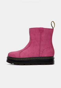 Pink ankle boots with a smooth suede finish, chunky black sole, yellow stitching, and a pull tab at the back for easy wear.