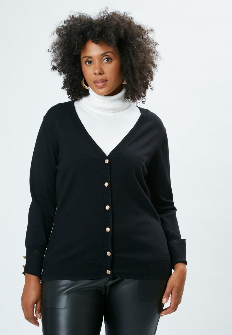 Cardigan nero con scollo a V, chiusura a bottoni e polsini a coste. Realizzato in materiale morbido, presenta dettagli in metallo dorato sui bottoni.
