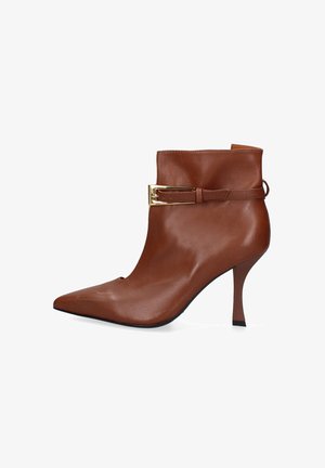 Bottine en cuir marron avec un embout pointu et un talon haut effilé, arborant un détail de boucle dorée et une texture lisse.